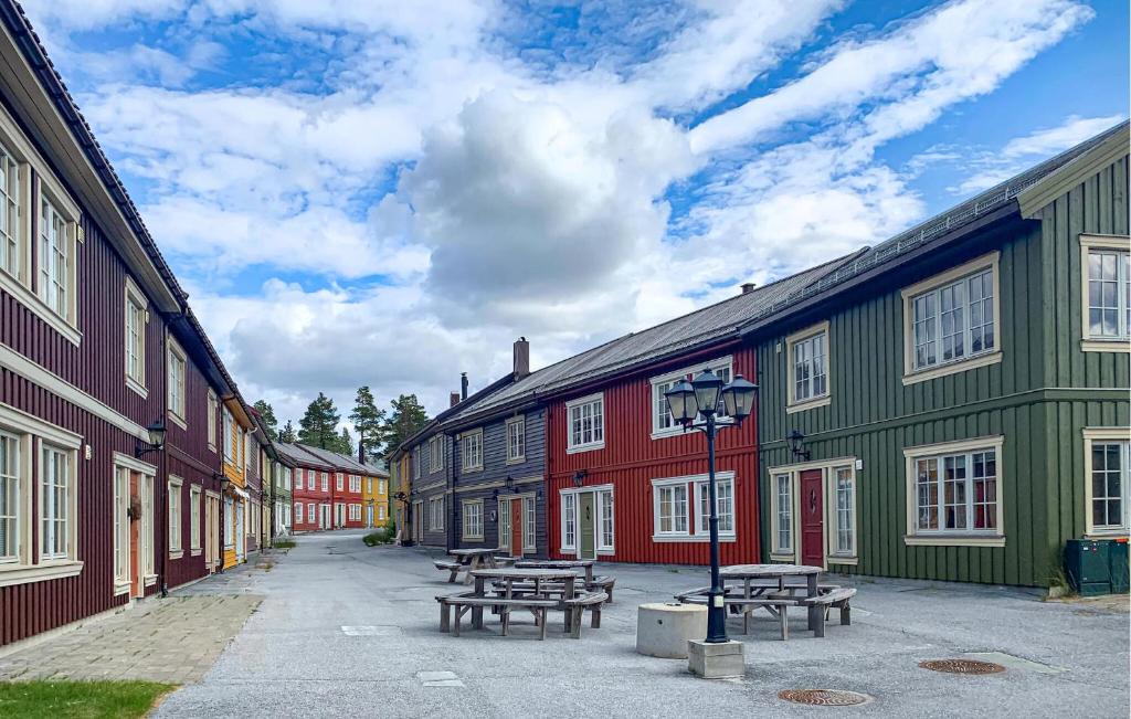 a row of colorful buildings with picnic tables in the street at Nice Apartment In Bjorli With Wifi in Bjorli