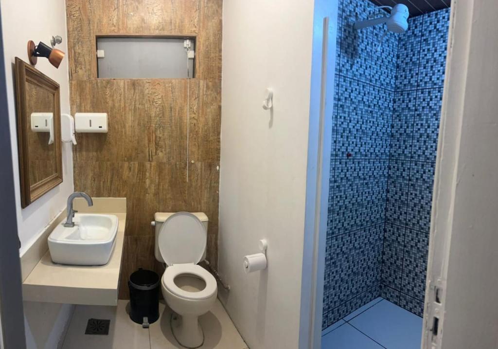 a bathroom with a toilet and a sink and a shower at Nativo Hostel in Arraial do Cabo