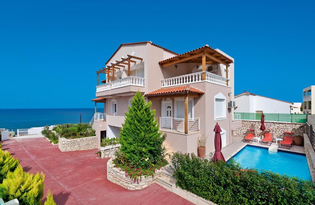 een villa met een zwembad en een huis bij Villa Apollon in Sfakaki