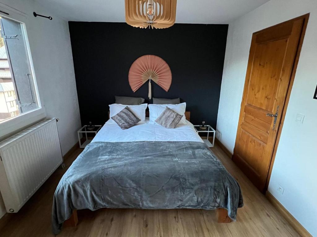 une chambre avec un grand lit avec un mur noir dans l'établissement Chamonix Charmant duplex 4 personnes et un enfant, à Chamonix-Mont-Blanc