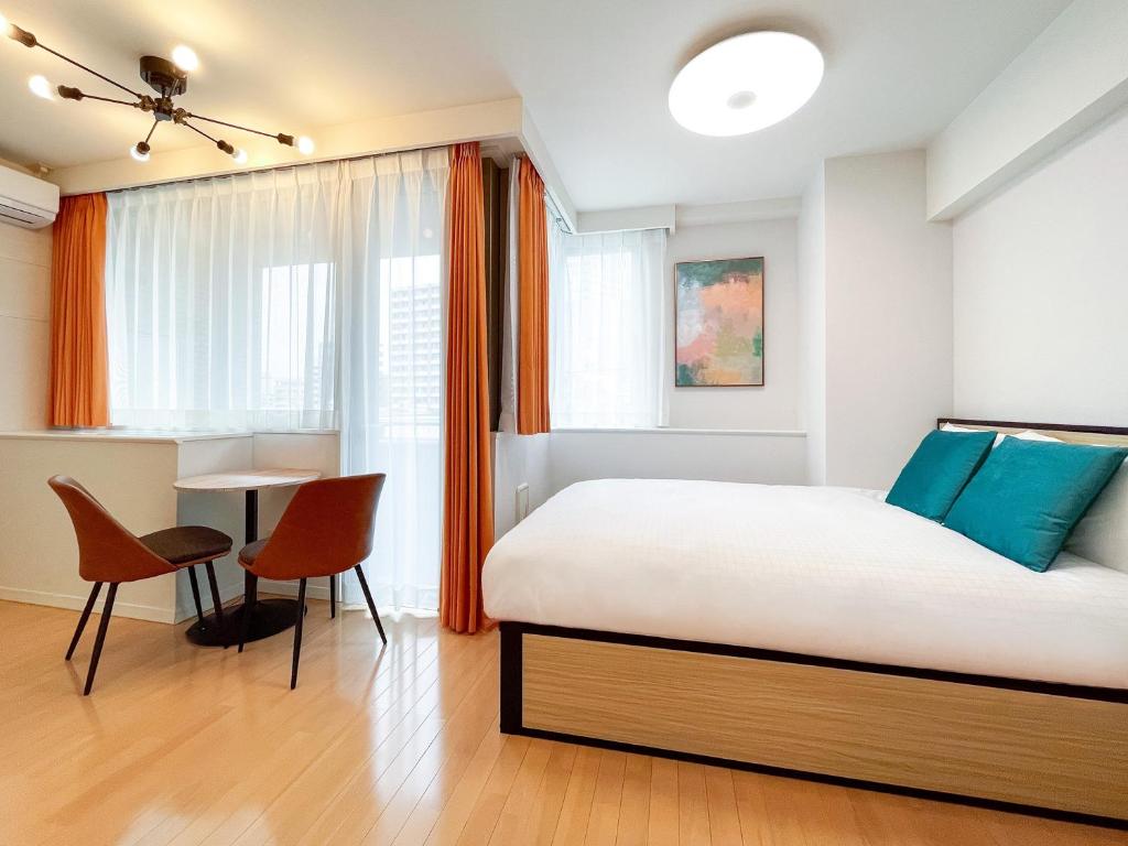 een slaapkamer met een bed, een tafel en stoelen bij Luce Takanawa in Tokyo