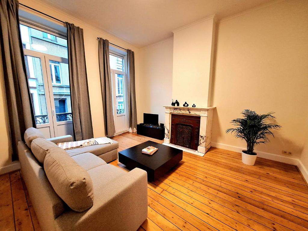 ein Wohnzimmer mit Couch und Kamin in der Unterkunft Le Duplex-suite Joséphine in Brüssel