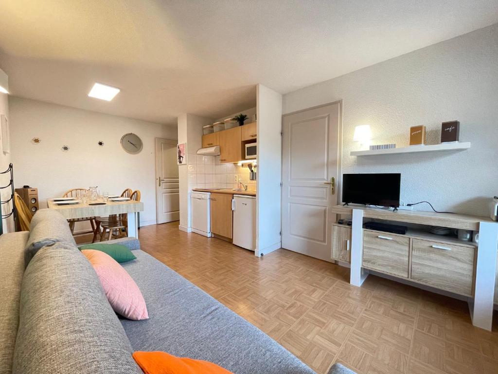 un salon avec un canapé et une cuisine dans l'établissement Appartement 6 pers. avec piscine aux pieds des pistes - FR-1-505-218, à Flumet
