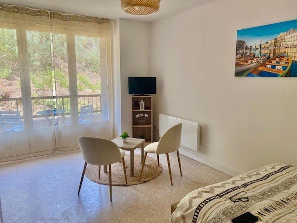 - une chambre avec une table, deux chaises et un lit dans l'établissement Studio confortable avec balcon, WIFI, proche cures - FR-1-703-190, à Amélie-les-Bains-Palalda