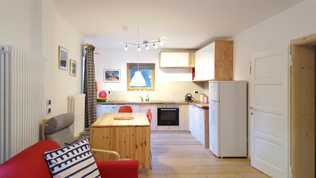 a small kitchen with a table and a refrigerator at Casa Alfredino in Rocca Pietore