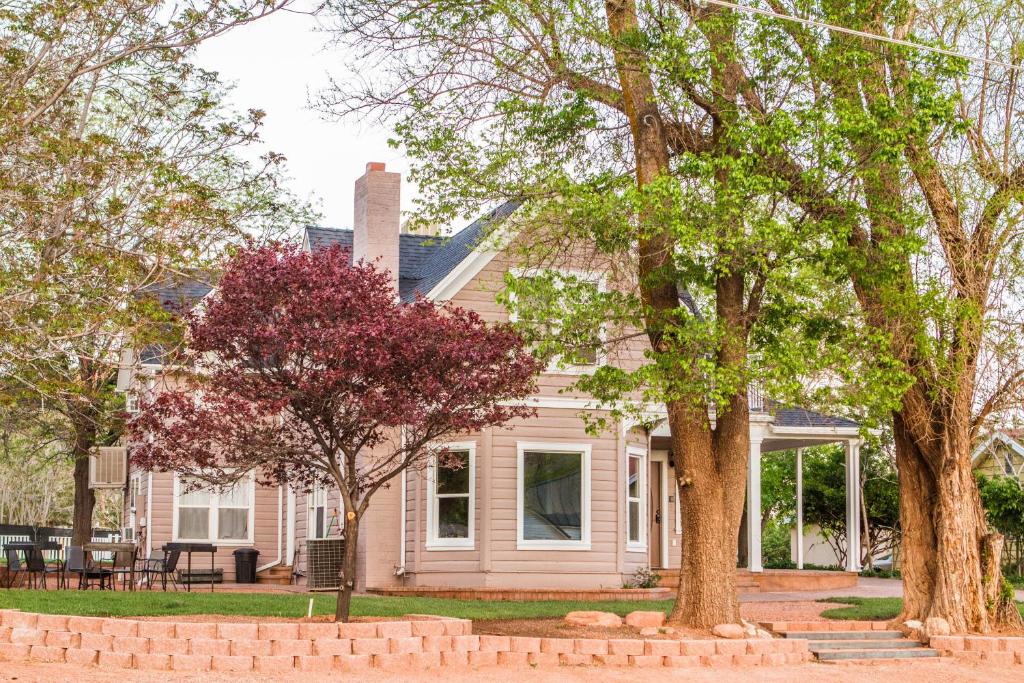 a pink house with trees in front of it at Grand Circle Lodge in Kanab