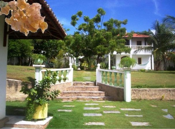uma casa com uma cerca branca e escadas num quintal em Residência Pancho Villa em Canoa Quebrada