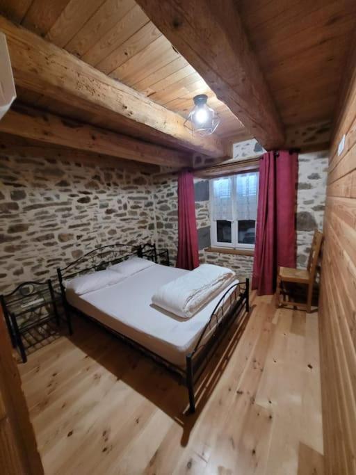 une chambre avec un lit et un mur de briques dans l'établissement Maison à la campagne, à Alleuze
