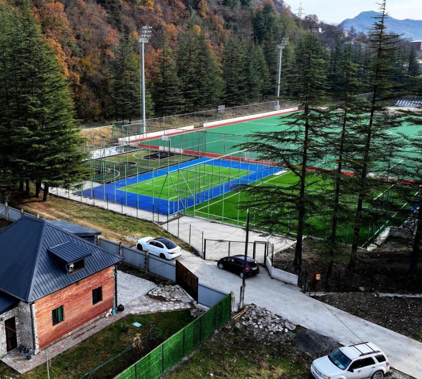 an overhead view of a tennis court with cars parked at WoodStar/ტყის ვარსკვლავი in Ambrolauri