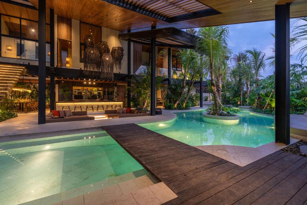 an exterior view of a house with a swimming pool at Villa Baratega - Dreamy Urban Tropical 6BR Villa for Large Group in Kerobokan