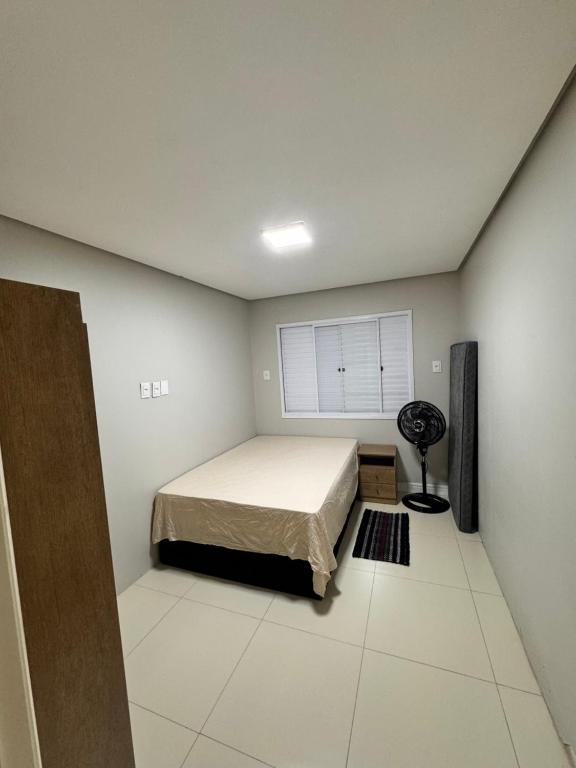 ein Schlafzimmer mit einem Bett und einem Fenster in der Unterkunft Casa em imbe in Imbé