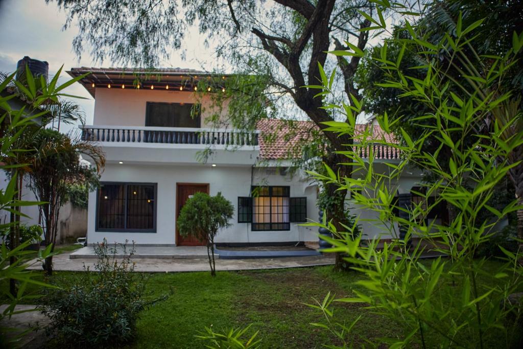 a white house with a garden in front of it at Comfortable and Spacious house in Arusha