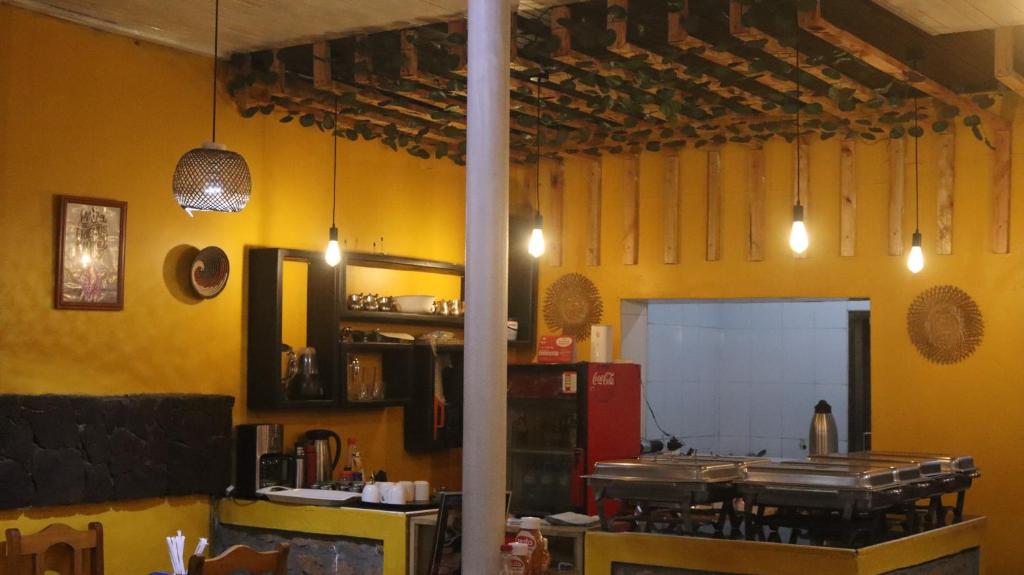 Una cocina con paredes amarillas y un mostrador en una habitación. en Santaviva Hotel, en Kisoro