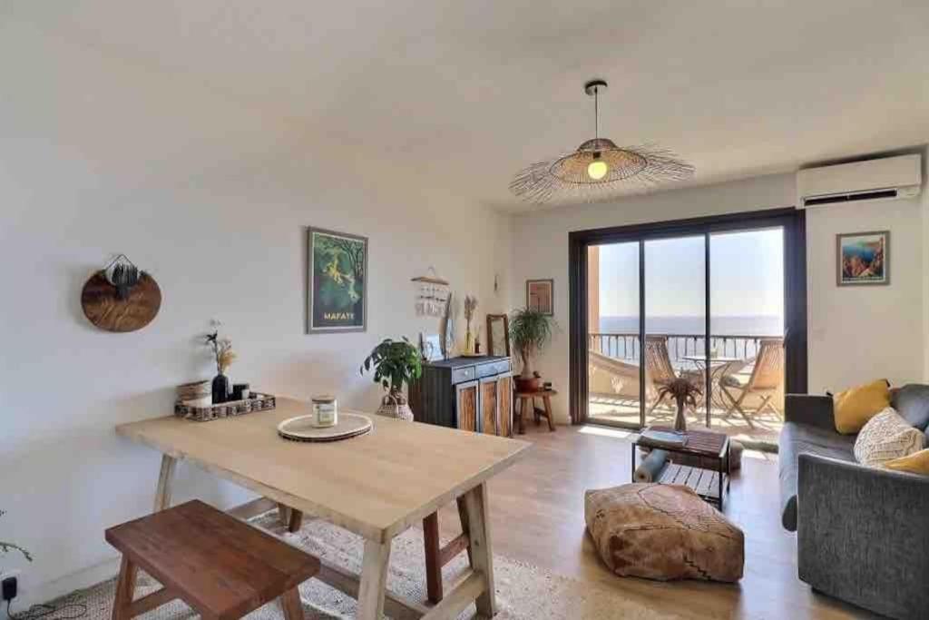 a living room with a table and a couch at Bel appartement cozy avec magnifique vue mer in Ajaccio