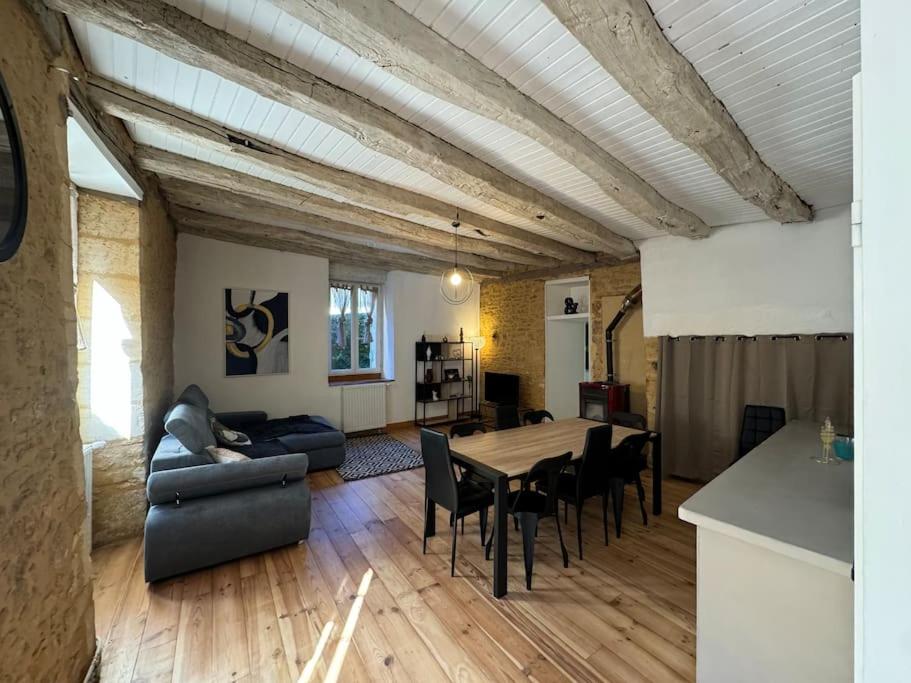 un grand salon avec une table et des chaises dans l'établissement L'échappée Sarladaise - Gîte avec jardin, à Sarlat-la-Canéda