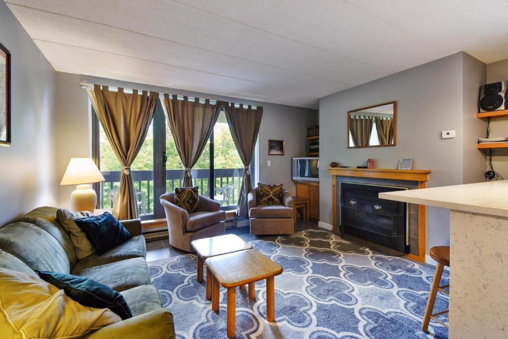 a living room with a couch and a fireplace at Pinnacle E15 in Killington