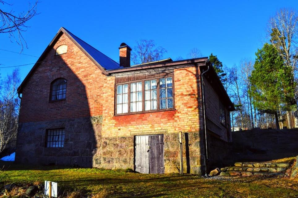 una vieja casa de ladrillo sentada en la cima de un campo en Marston Hill en Mullsjö