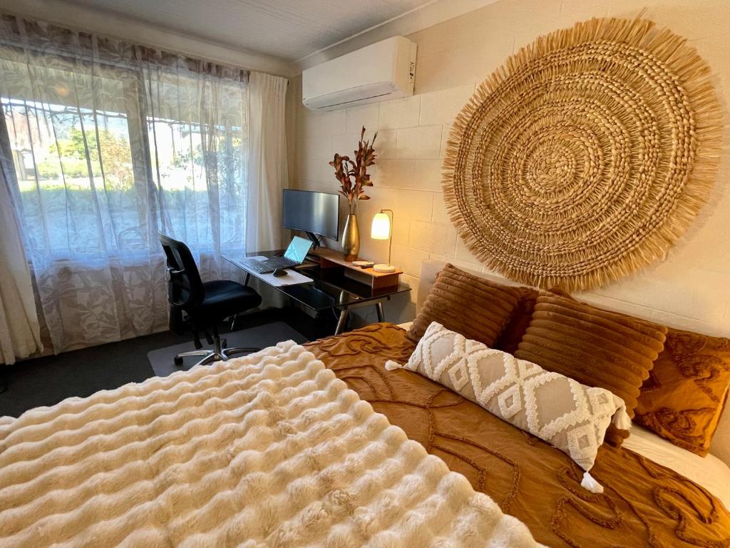 a bedroom with a bed and a desk with a computer at White Rabbit Mountain Guest House in Mount Beauty