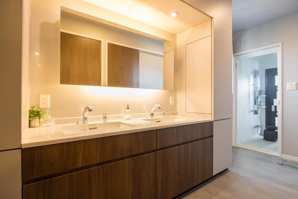 a bathroom with two sinks and a large mirror at Buena Vista Ohori Park in Fukuoka