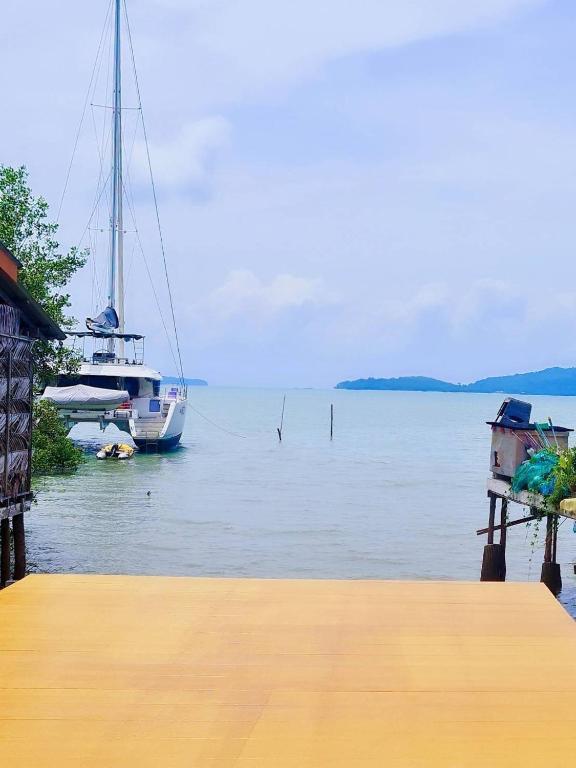 a dock with a boat in a body of water at Star house in Ko Lanta