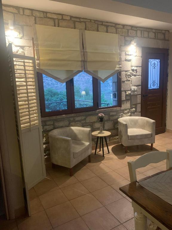 a living room with two chairs and a window at Pera Vrisi in Zátouna