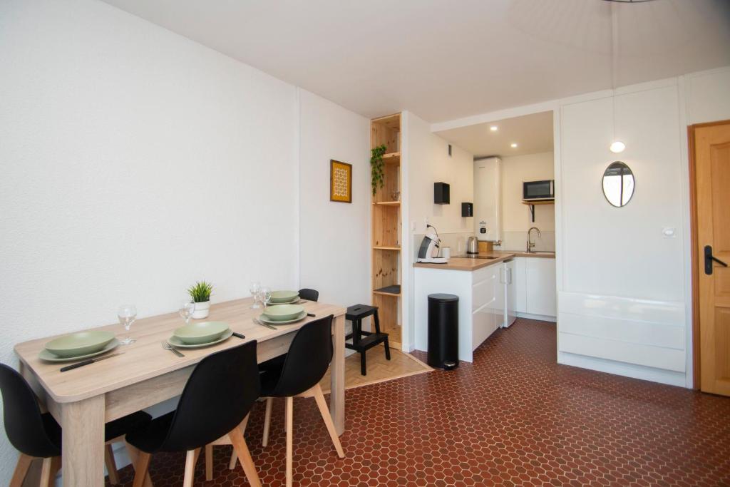 une salle à manger avec une table et des chaises et une cuisine dans l'établissement La Maëlea - Appt à Saint-Lary-Soulan pour 5, à Saint-Lary-Soulan