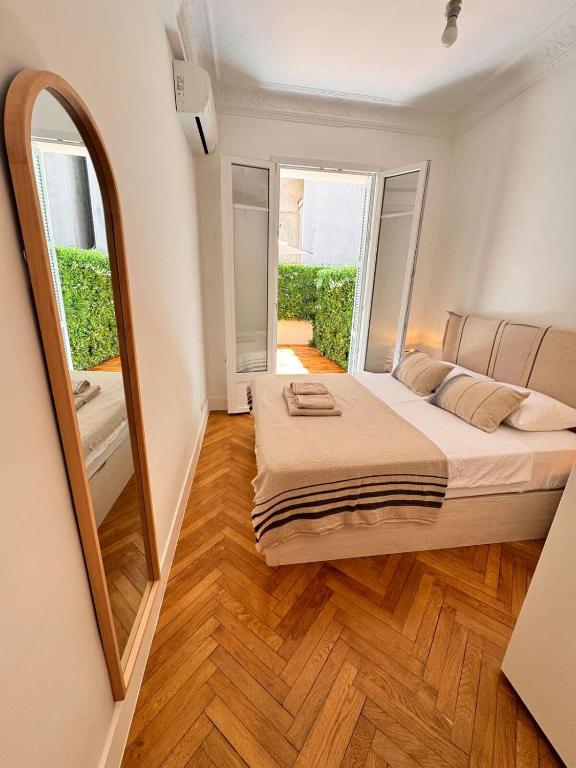 une chambre avec un grand lit et un miroir dans l'établissement Luxury Central Condo with Private Terrace in Nice, à Nice