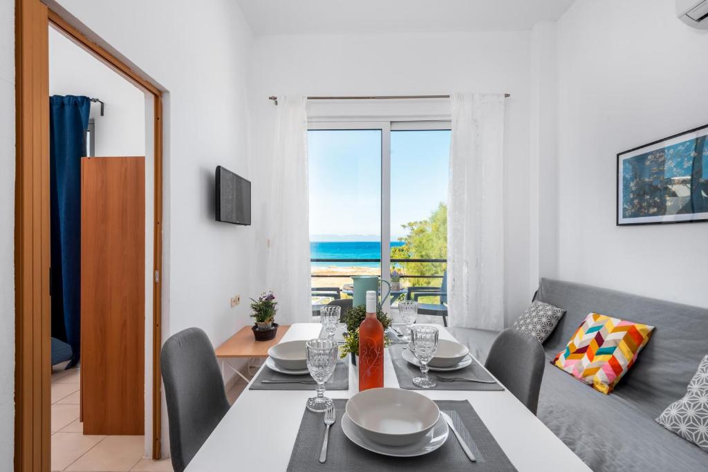 een eetkamer met een tafel en uitzicht op de oceaan bij Sea Apartment Ixia Ialisos in Ialyssos