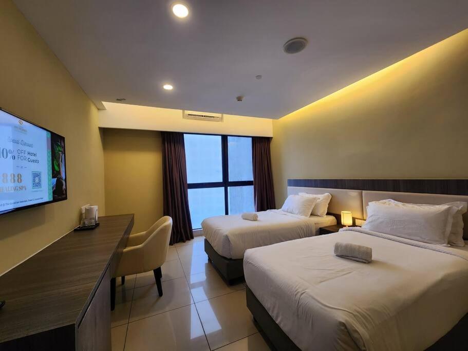 Una habitación de hotel con dos camas y un televisor de pantalla plana. en Ion Genting 2singlebed freeWi-fi 71612, en Genting Highlands