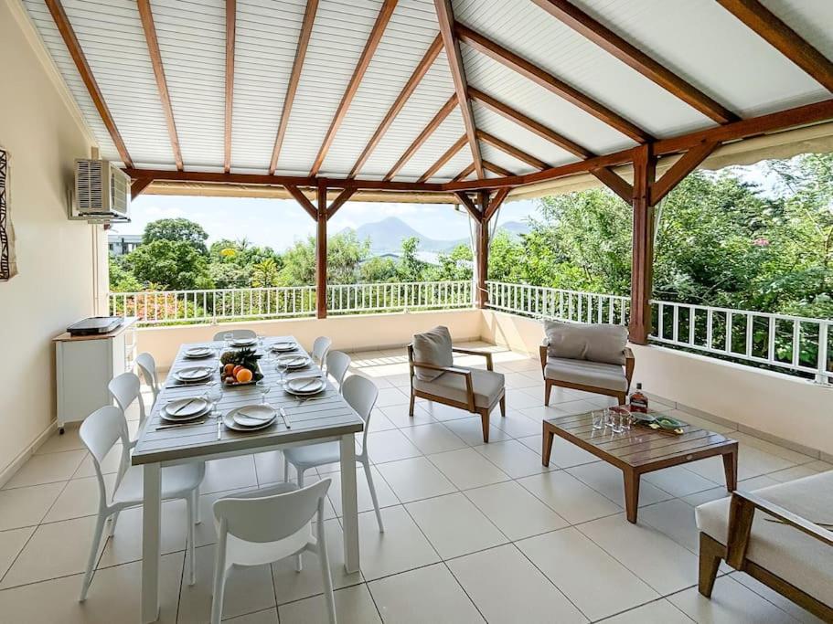 una sala da pranzo con tavolo e sedie su un balcone di Bel appartement duplex T4 Laboté, vue mer, a 600m de la plage de Diamant a Le Diamant