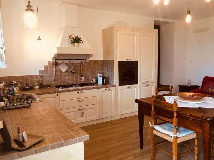 a kitchen with white cabinets and a table with a table sidx sidx at Villa Ca' Doccio Holiday in Auditore