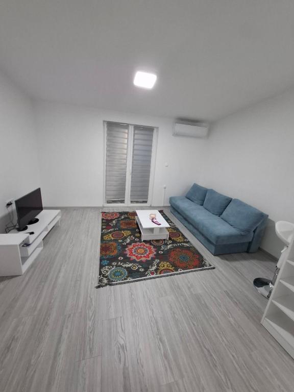 a living room with a blue couch and a rug at Stan na dan Djogić in Nevesinje