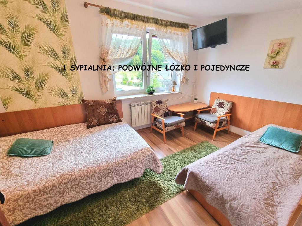 Apartament Kacperek samo centrum, Willowa 4A - 2 sypialnie, salon - dla rodziny 4-5 os في شتوروك: غرفة بها سريرين وطاولة ونافذة