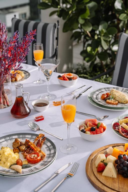 a table with plates of food and glasses of orange juice at The Raintree, St. Mary’s Road in Chennai