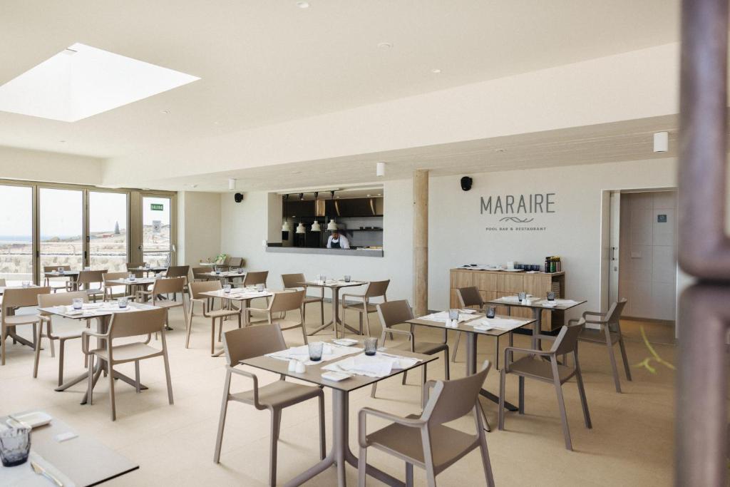 a restaurant with tables and chairs in a room at BANCAL HOTEL and SPA in San Sebastián de la Gomera