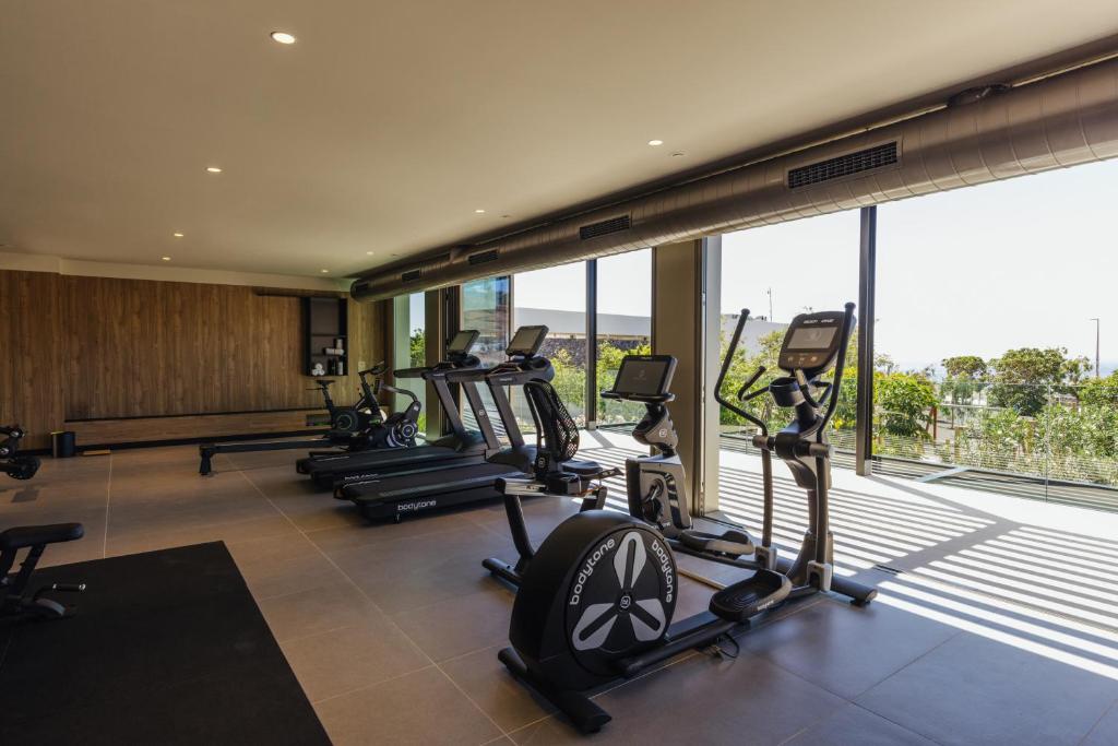 a gym with a row of treadmills and elliptical machines at BANCAL HOTEL and SPA in San Sebastián de la Gomera