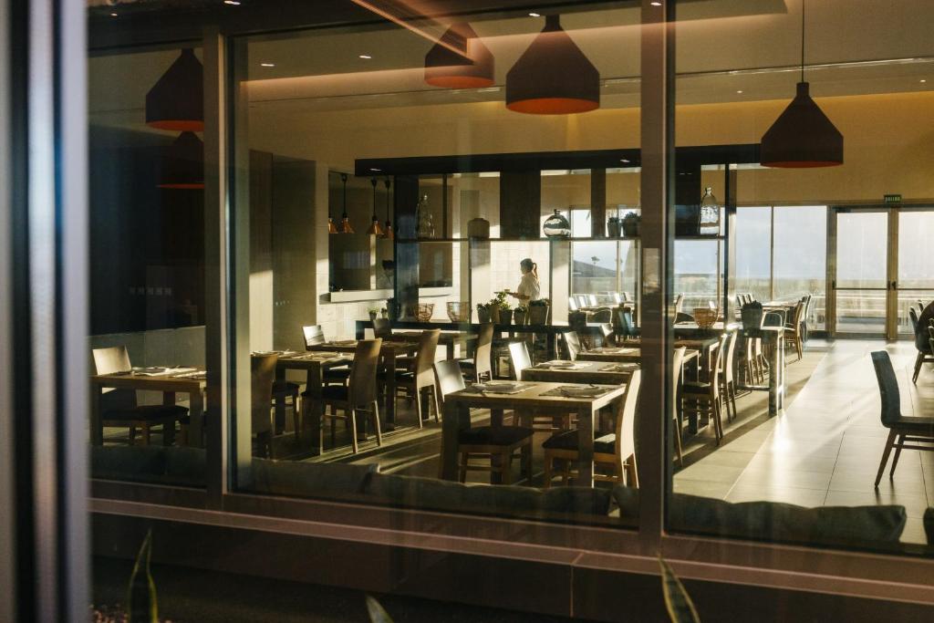 a dining room with tables and chairs and a window at BANCAL HOTEL and SPA in San Sebastián de la Gomera