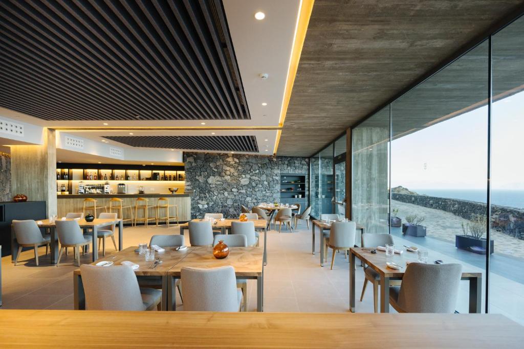 a restaurant with tables and chairs and a view of the ocean at BANCAL HOTEL and SPA in San Sebastián de la Gomera