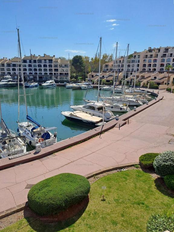 un port de plaisance avec des bateaux dans l'eau et des bâtiments dans l'établissement Marcogdu- Proche de Saint-Tropez Appartement pour 4 personnes avec vue sur la marina, à Cogolin