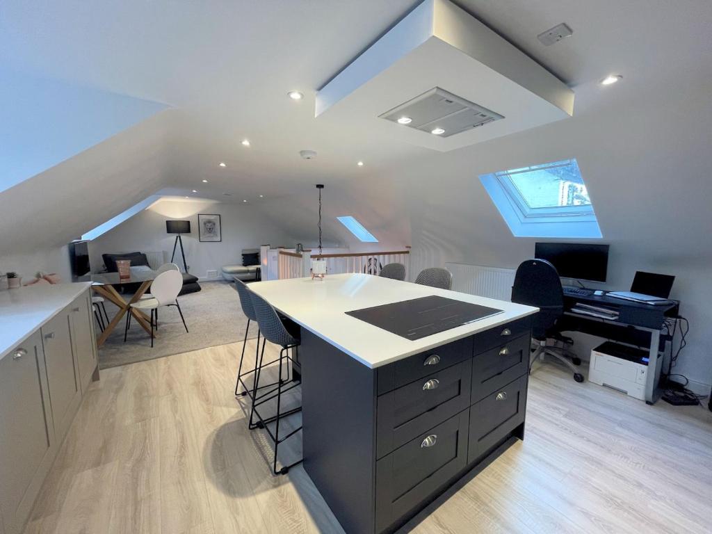 an attic kitchen with an island and a desk in it at Pass the Keys Stunning Cosy Cottage in Historic Moffat in Moffat