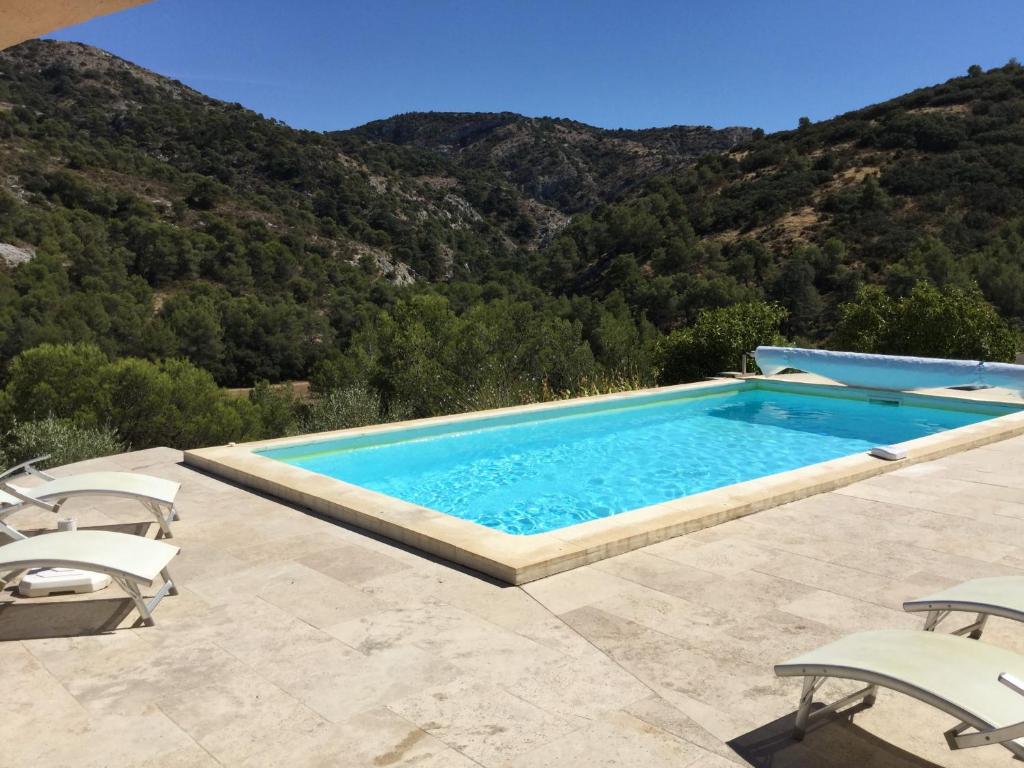 une piscine avec des chaises et des montagnes en arrière-plan dans l'établissement pretty gite with pool in cavaillon, beautiful view on the luberon mountains, 4 people., à Cavaillon