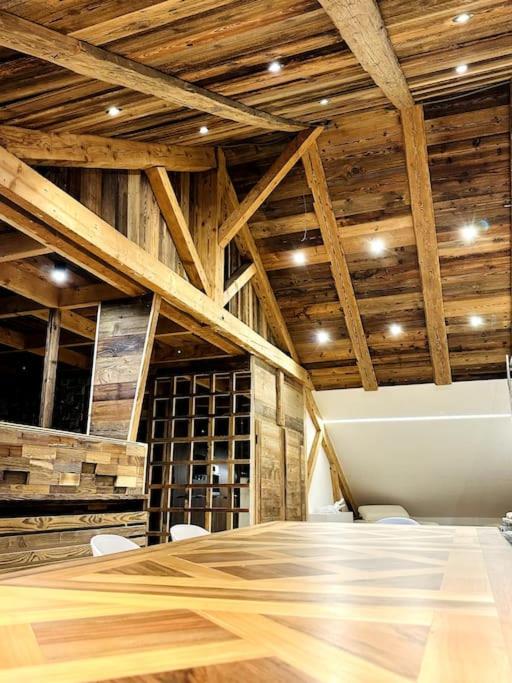 Cette chambre dispose d'une table, de chaises et de plafonds en bois. dans l'établissement Le Charlet Versaille, à Passy