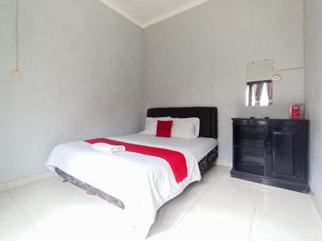 Un dormitorio con una cama y una cómoda. en RedDoorz at Penginapan Hello Pacitan, en Pacitan