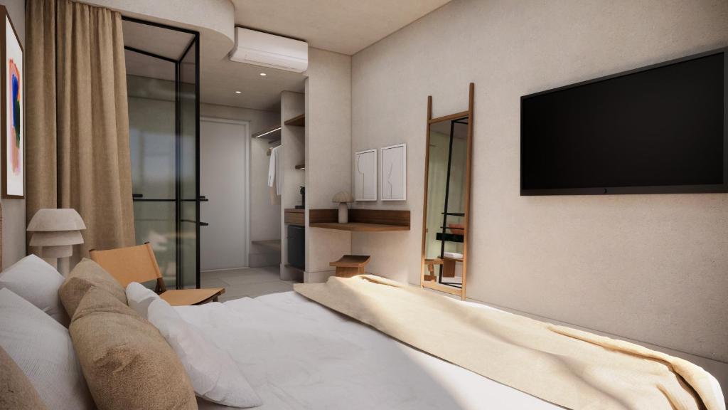 a hotel room with a bed and a flat screen tv at Cavo Marelia in Amoopi
