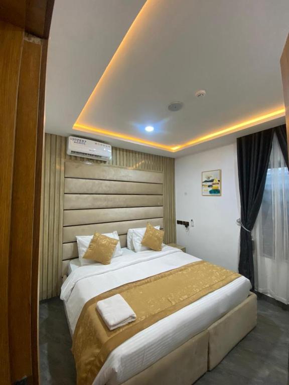 伊巴丹Lighthouse Inn and suites的卧室配有一张带黄色枕头的大型白色床。