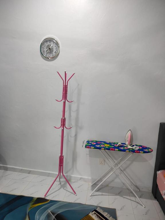 a room with a table and a clock on the wall at MAA Roomstay C in Kuala Terengganu