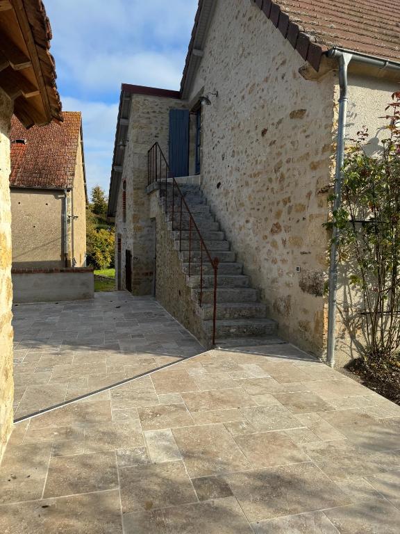 une passerelle en pierre menant à un bâtiment avec un escalier dans l'établissement Détente et charme au Domaine, à Coust