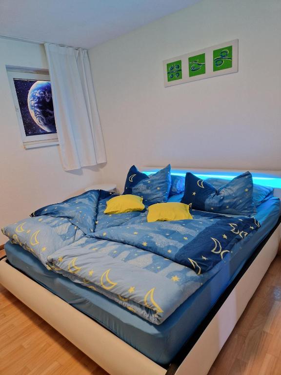a bed with blue sheets and yellow pillows at Ferienwohnung Esther in Naila