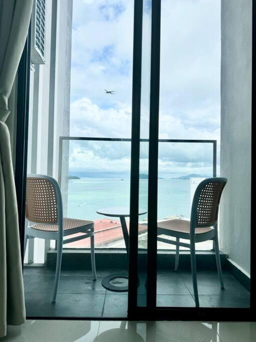 a balcony with a table and chairs and a view of the ocean at The Shore Suite seaview balcony Free Wifi & Netflix in Kota Kinabalu
