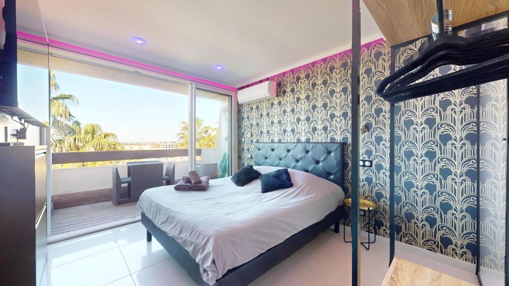 une chambre avec un lit et une grande fenêtre dans l'établissement Village Naturiste Cap d'Agde, Studio Luxe Port Nature 7, au Cap d'Agde
